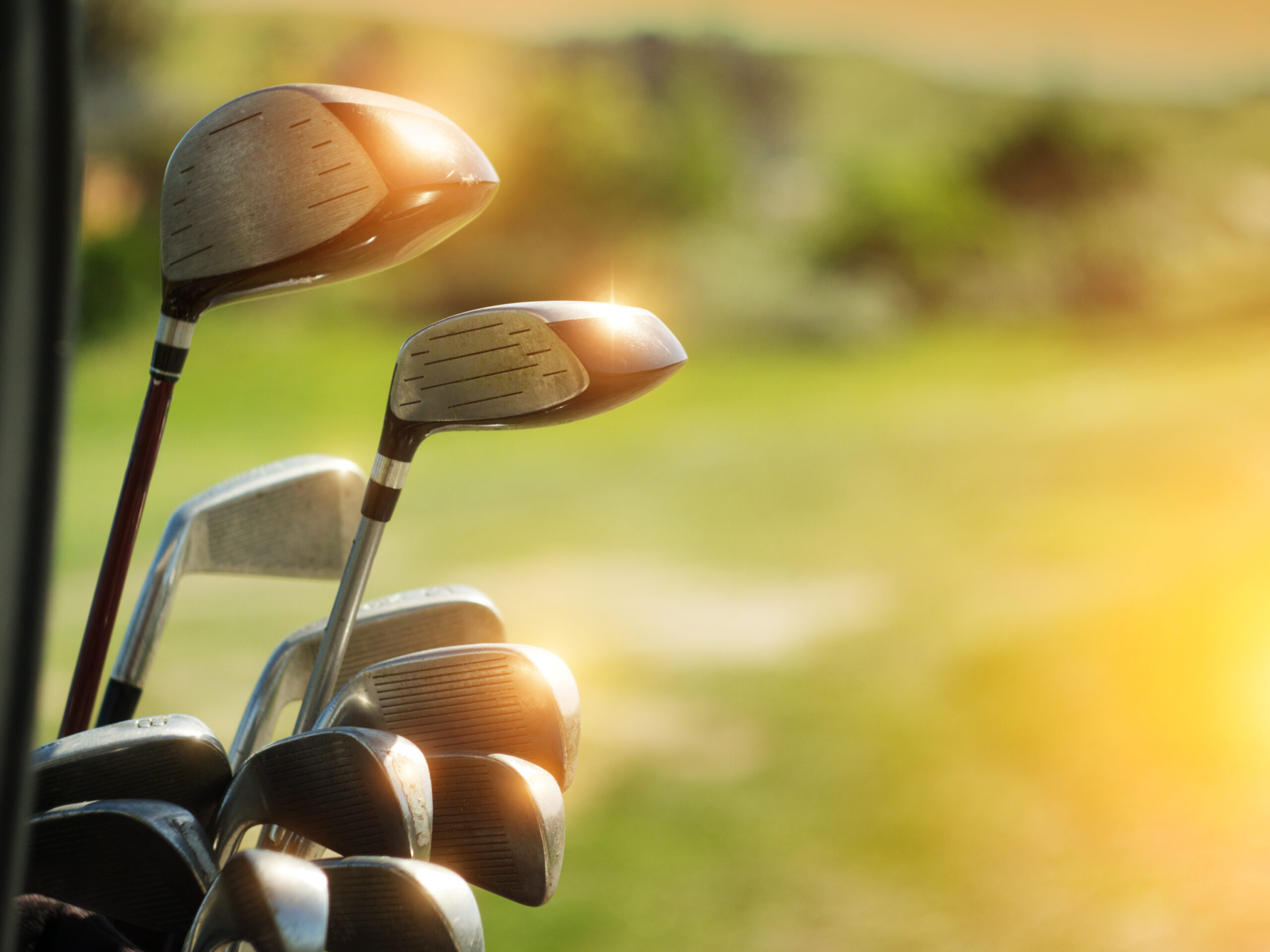 golf,clubs,drivers,over,green,field,background